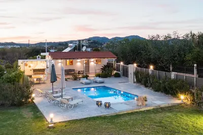 a backyard with a swimming pool and a house at Reni Garden House in Afantou