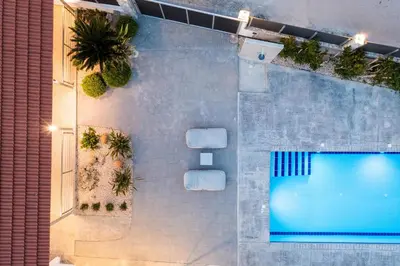 an overhead view of a swimming pool with palm trees at Reni Garden House in Afantou