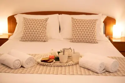 a tray of food and towels on a bed at Reni Garden House in Afantou