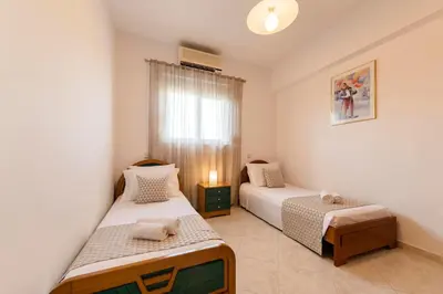 a bedroom with two beds and a window at Reni Garden House in Afantou
