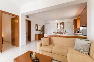 a living room and kitchen with a couch and a table at Reni Garden House in Afantou