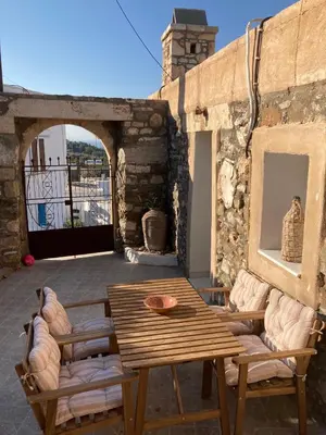 a wooden table and chairs on a patio at Yiannis Village house in Asklipiḯon