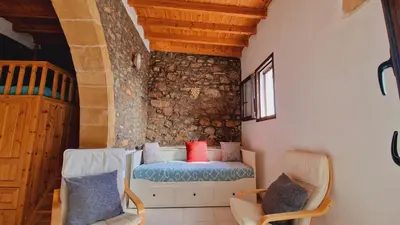 a living room with a bench and two chairs at Yiannis Village house in Asklipiḯon