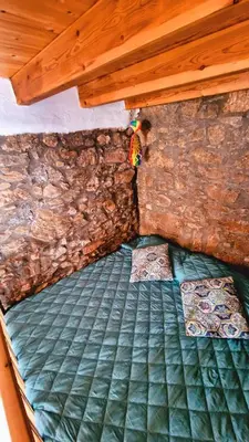 a bed in a room with a stone wall at Yiannis Village house in Asklipiḯon