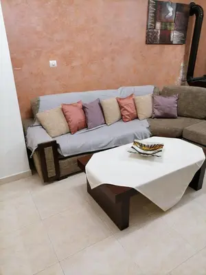 a living room with a couch and a table at MARIALENAS HOUSE in Archangelos