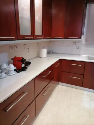 a kitchen with wooden cabinets and white counter tops at MARIALENAS HOUSE in Archangelos