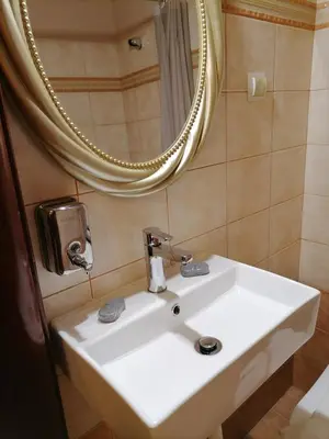 a bathroom with a white sink and a mirror at MARIALENAS HOUSE in Archangelos