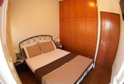 a bedroom with a bed and a wooden cabinet at Aegean Seaview in Haraki