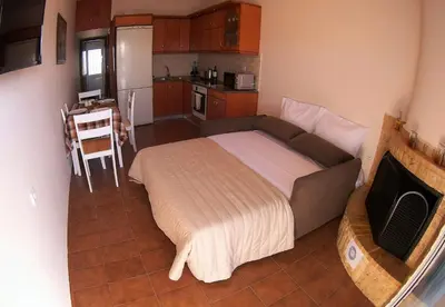a small bedroom with a bed and a kitchen at Aegean Seaview in Haraki