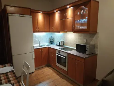 a kitchen with wooden cabinets and a white refrigerator at Aegean Seaview in Haraki