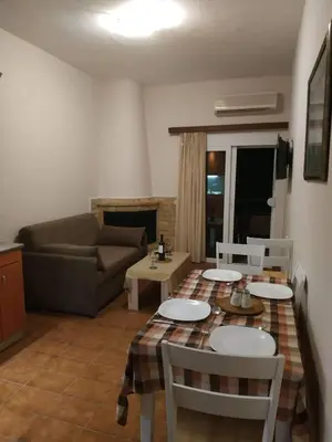 a living room with a table and chairs and a couch at Aegean Seaview in Haraki