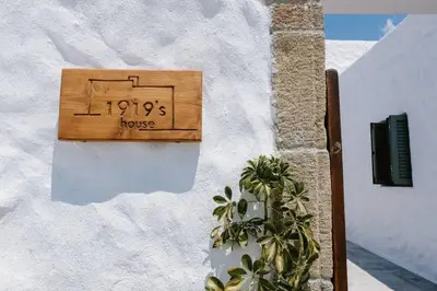 a house sign on the side of a building at 1919's House in Asklipiḯon