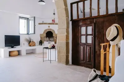a living room with a wooden door and a television at 1919's House in Asklipiḯon