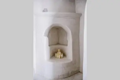 a group of candles sitting in a niche in a building at 1919's House in Asklipiḯon