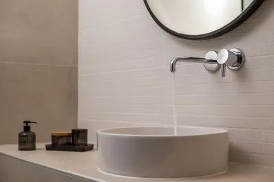 a white sink with a faucet and a mirror at Vanik Suites in Faliraki