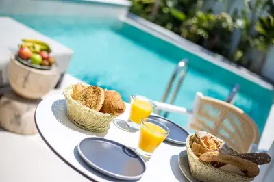 a table with baskets of bread and glasses of orange juice at Vanik Suites in Faliraki