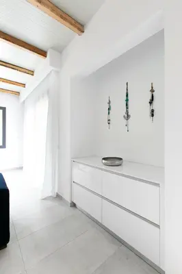 a white kitchen with a large white dresser at DASÝLIO - earthy living homes in Triánta