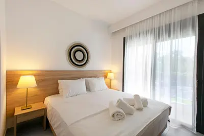 a bedroom with a white bed with towels on it at DASÝLIO - earthy living homes in Triánta