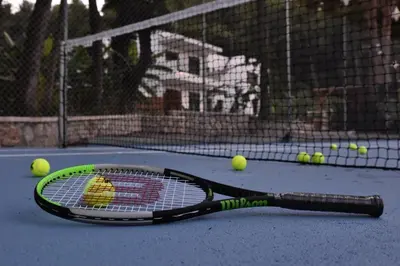 a tennis racket and tennis balls on a tennis court at DASÝLIO - earthy living homes in Triánta