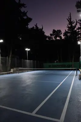 an empty tennis court at night with lights at DASÝLIO - earthy living homes in Triánta