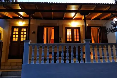 a house with a porch with a white fence at Traditional Villa Efterpi in Halki