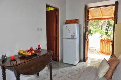 a kitchen with a table and a white refrigerator at Traditional Villa Efterpi in Halki