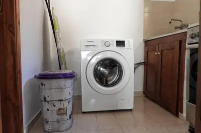 a washing machine in a kitchen with a trash can at Traditional Villa Efterpi in Halki