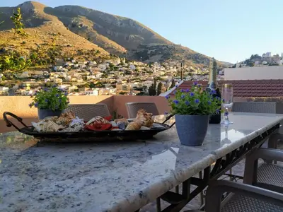 a plate of food on a table with a view at Vila Elion Myloi in Symi