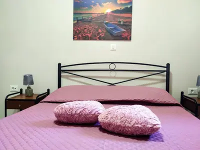 a bedroom with a pink bed with two pillows on it at Vila Elion Myloi in Symi