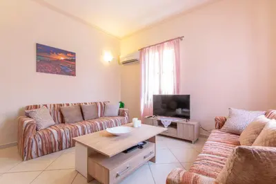 a living room with two couches and a television at Vila Elion Myloi in Symi