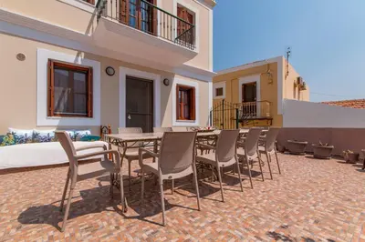 a patio with a table and chairs in a house at Vila Elion Myloi in Symi