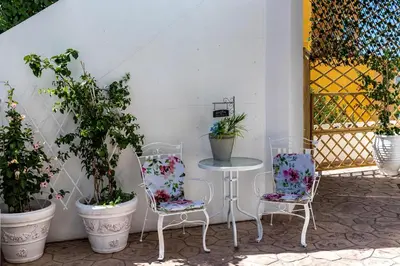 a table and two chairs with plants on a patio at Evi's Afandou Suite in Afantou