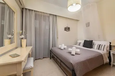 a bedroom with a bed and a desk and a window at Evi's Afandou Suite in Afantou