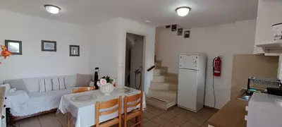 a kitchen and living room with a table and a refrigerator at VILLA ELENA in Halki