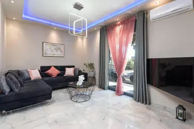 a living room with a couch and a tv at Lux City Apartment in Rhodes Town