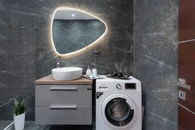 a bathroom with a washing machine and a mirror at Lux City Apartment in Rhodes Town
