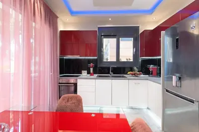 a kitchen with red cabinets and a glass table at Lux City Apartment in Rhodes Town