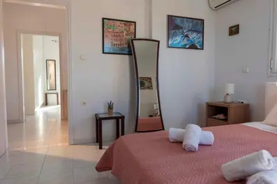 a bedroom with a bed and a mirror on the wall at Villa George Rhodes in Archangelos