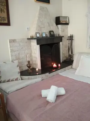 a room with a fireplace with two towels on a bed at Villa George Rhodes in Archangelos