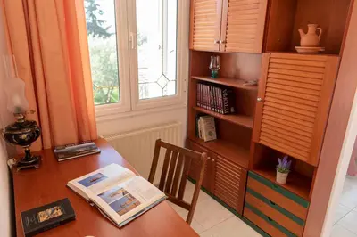 a desk with a book on it next to a window at Villa George Rhodes in Archangelos