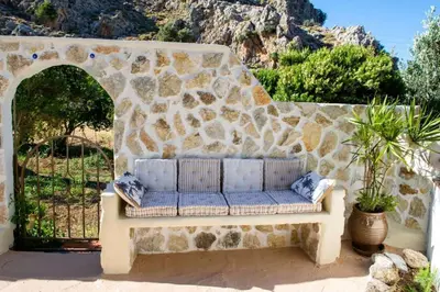 a stone wall with a couch in front of a gate at Atlantic Cave Haven-Seaside, Fully Equipped in Kolimbia