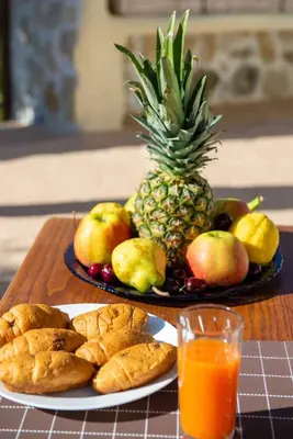 a table topped with a plate of fruit and a pineapple at Atlantic Cave Haven-Seaside, Fully Equipped in Kolimbia