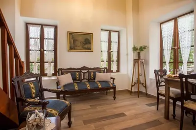 a living room with chairs and a table and windows at The Knight's House Old Town Rhodes in Rhodes Town