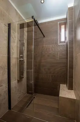 a walk in shower with a glass door at The Knight's House Old Town Rhodes in Rhodes Town