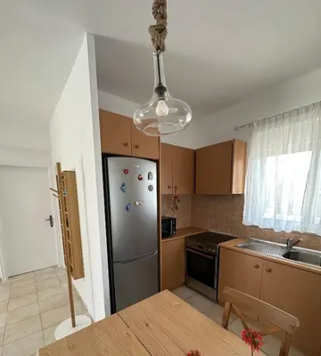 a kitchen with a stainless steel refrigerator and a table at Secret Edem in Kolimbia