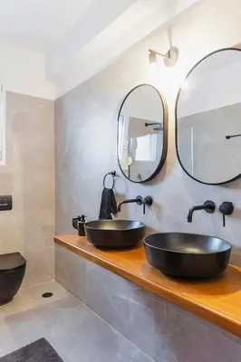 a bathroom with two sinks and two mirrors at Villa Tranquility in Psinthos