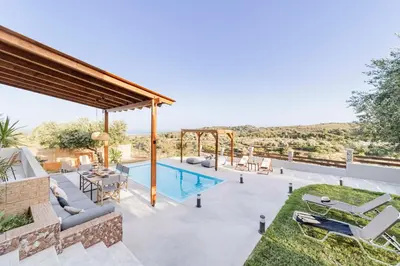 a patio with a pool and a table and chairs at Villa Tranquility in Psinthos