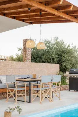 a patio with a table and chairs and a grill at Villa Tranquility in Psinthos