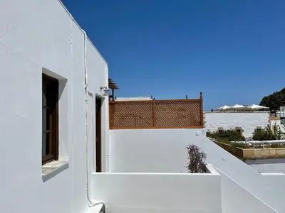 a white house with a white wall and a window at Teresa's Home in Líndos
