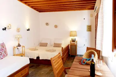 a bedroom with two beds and a table with a lamp at Teresa's Home in Líndos